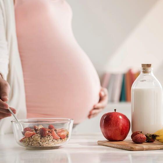 Imagen de una mujer embarazada riegiendo su alimentación , Clínica Ennova