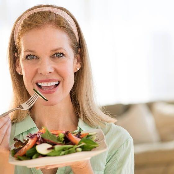 Imagen de mujer con menopausia comiendo saludable gracias a Clínica Ennova, Castellón