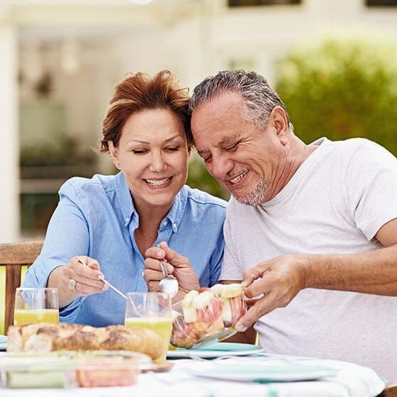 Imagen de una pareja de adultos comiendo saludable gracias a Clínica Ennova, Castellón