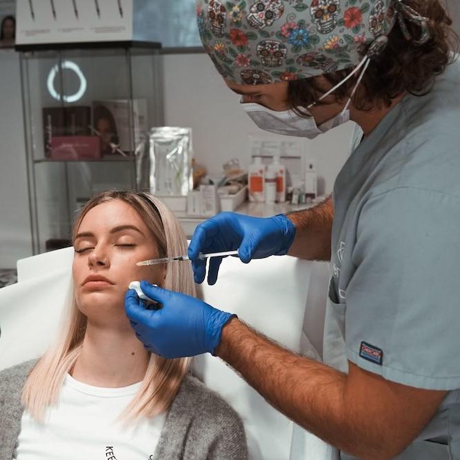 Imagen de una mujer aplicándose el tratamiento para acné, en Clínica Ennova