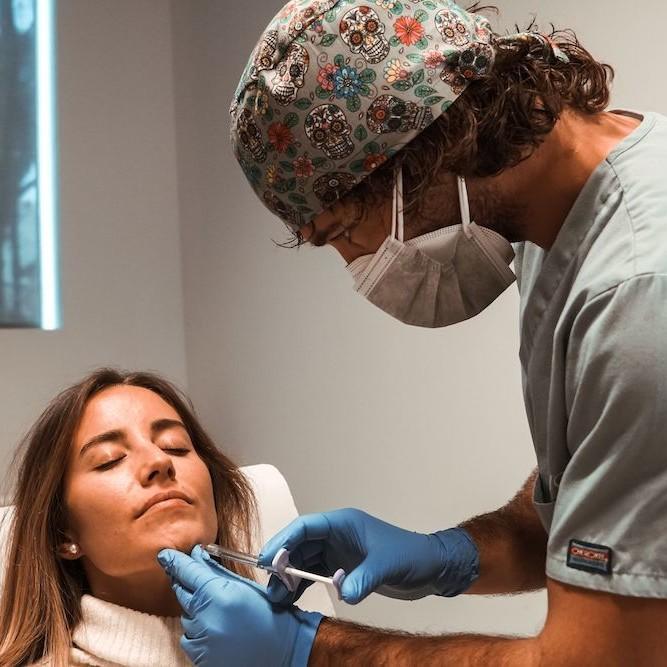 Imagen de mujer aplicándose ácido hialurónico para relleno de mentón, en Clínica Ennova, Castellón.