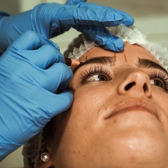 Imagen de mujer preparándose para tratamiento de micropigmentación en Clínica Ennova, Castellón