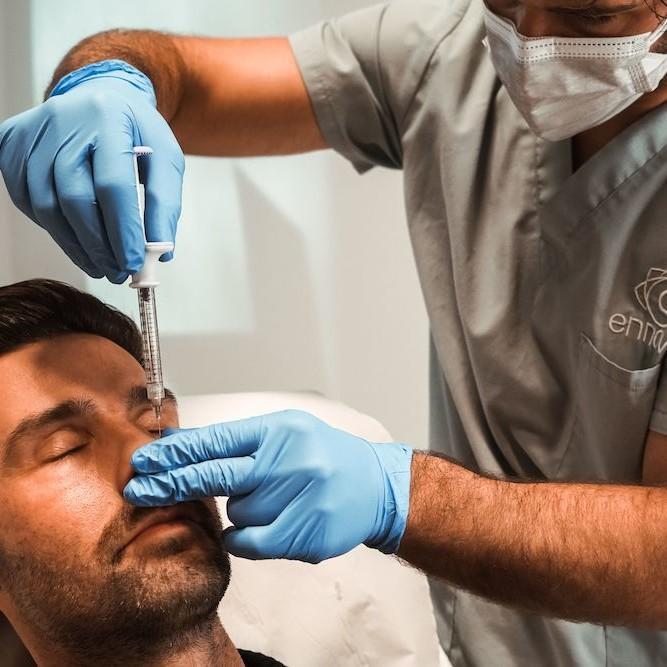 Imagen de hombre sometiéndose a tratamiento de rinomodelación con ácido hialurónico, Clínica Ennova, Castellón